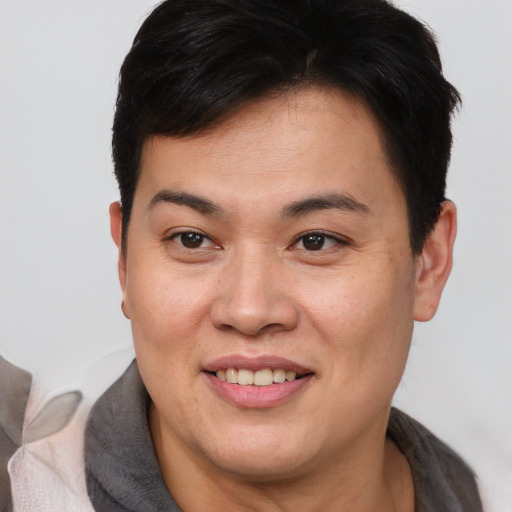 Joyful asian young-adult female with short  brown hair and brown eyes