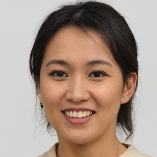 Joyful asian young-adult female with medium  brown hair and brown eyes