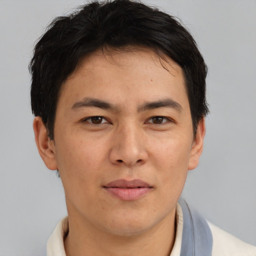 Joyful asian adult male with short  brown hair and brown eyes