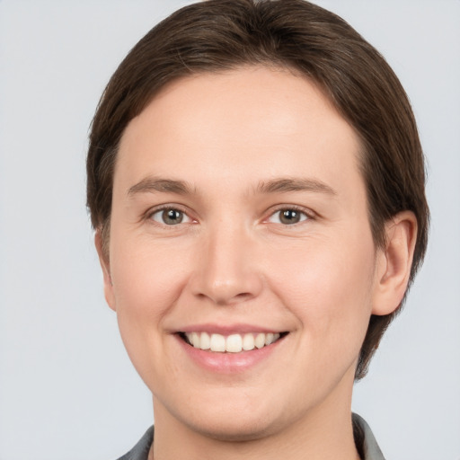 Joyful white young-adult female with medium  brown hair and grey eyes