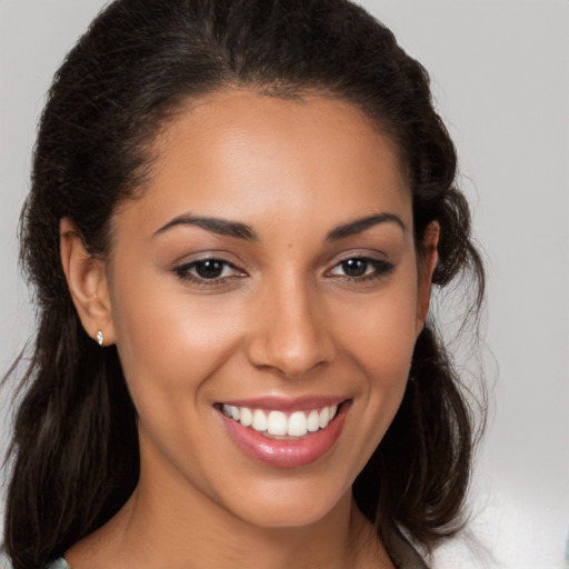 Joyful latino young-adult female with medium  brown hair and brown eyes