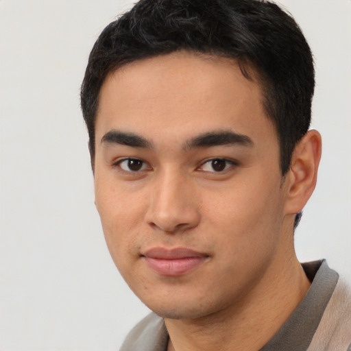 Joyful latino young-adult male with short  brown hair and brown eyes