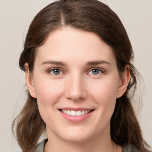 Joyful white young-adult female with medium  brown hair and grey eyes