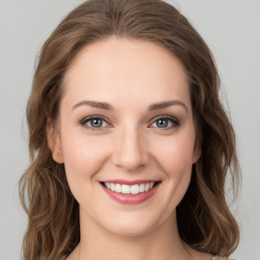 Joyful white young-adult female with long  brown hair and green eyes