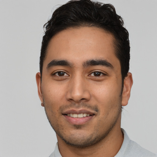 Joyful latino young-adult male with short  brown hair and brown eyes