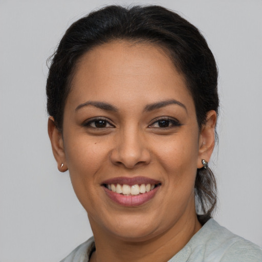 Joyful latino young-adult female with medium  brown hair and brown eyes