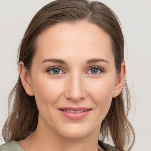 Joyful white young-adult female with medium  brown hair and grey eyes