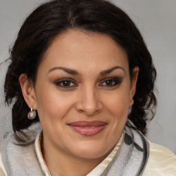 Joyful latino adult female with medium  brown hair and brown eyes