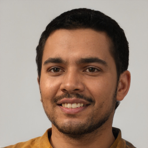 Joyful latino young-adult male with short  black hair and brown eyes