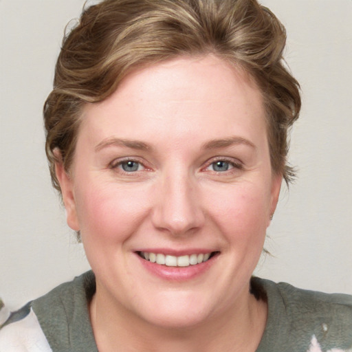 Joyful white young-adult female with medium  brown hair and blue eyes