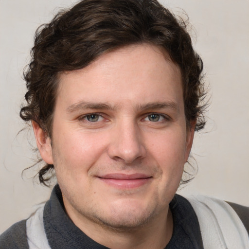 Joyful white young-adult male with short  brown hair and blue eyes