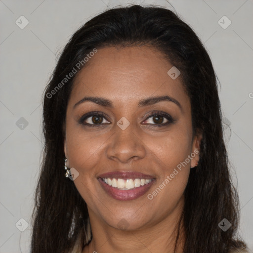 Joyful black young-adult female with long  brown hair and brown eyes