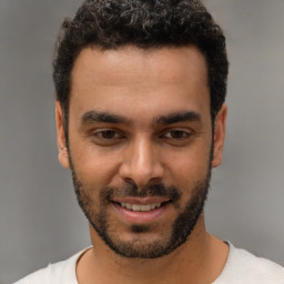 Joyful white young-adult male with short  black hair and brown eyes