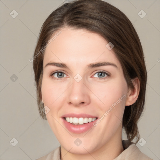 Joyful white young-adult female with medium  brown hair and green eyes