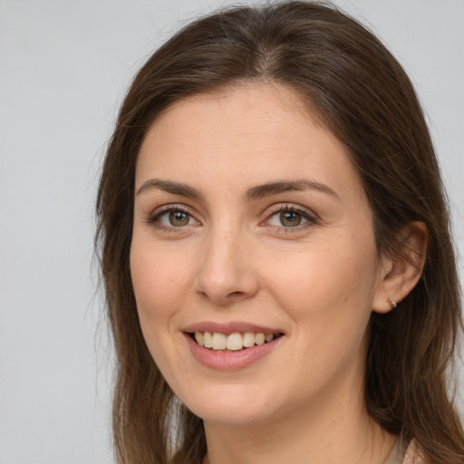 Joyful white young-adult female with long  brown hair and brown eyes