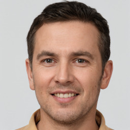 Joyful white young-adult male with short  brown hair and brown eyes