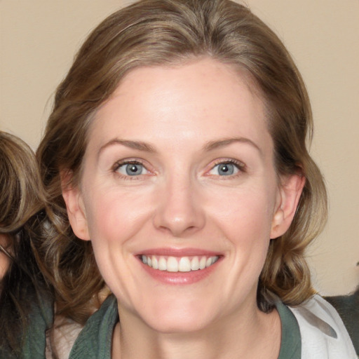 Joyful white adult female with medium  brown hair and blue eyes