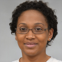 Joyful black adult female with short  brown hair and brown eyes