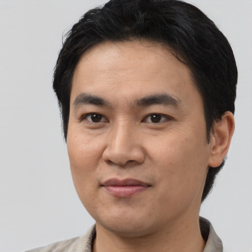 Joyful asian adult male with short  brown hair and brown eyes