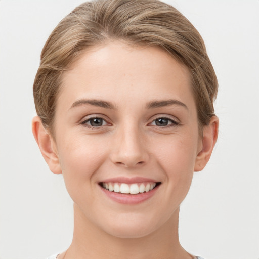 Joyful white young-adult female with short  brown hair and grey eyes