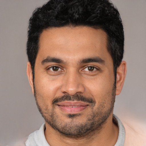 Joyful latino young-adult male with short  black hair and brown eyes