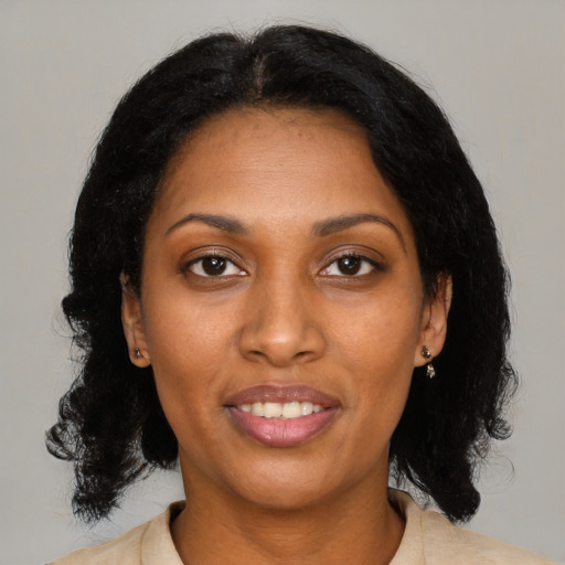Joyful black young-adult female with medium  black hair and brown eyes