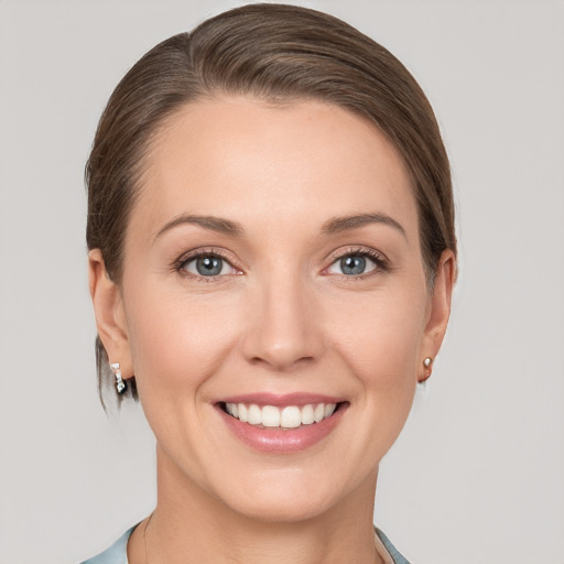 Joyful white young-adult female with medium  brown hair and grey eyes