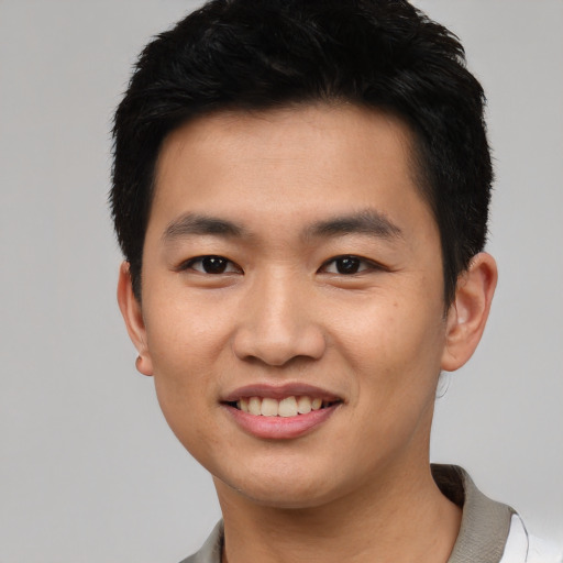 Joyful asian young-adult male with short  black hair and brown eyes