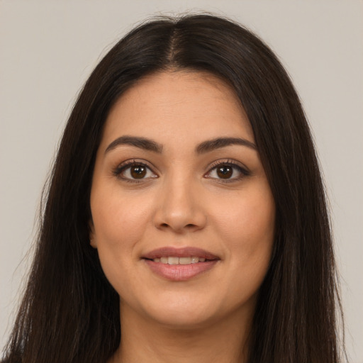 Joyful latino young-adult female with long  brown hair and brown eyes