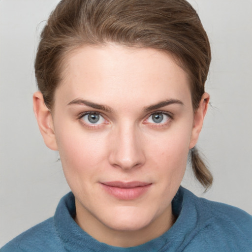 Joyful white young-adult female with short  brown hair and blue eyes