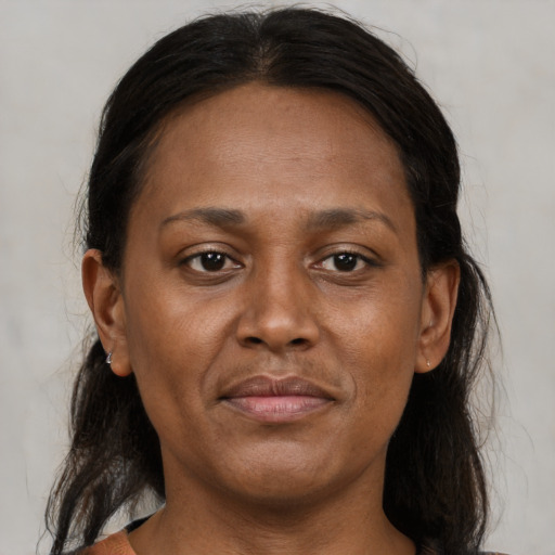 Joyful black adult female with medium  brown hair and brown eyes