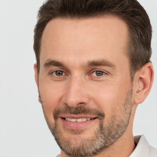 Joyful white adult male with short  brown hair and brown eyes