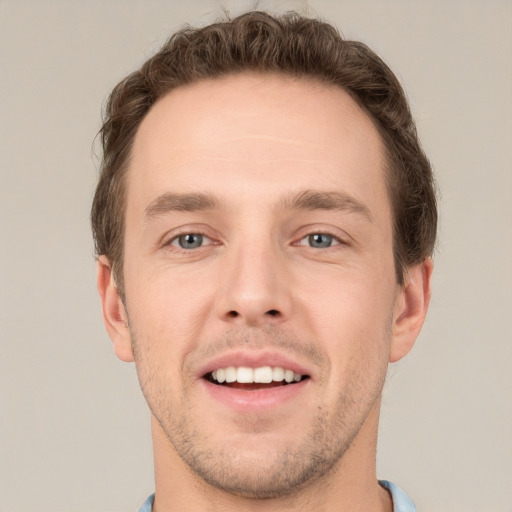 Joyful white young-adult male with short  brown hair and grey eyes