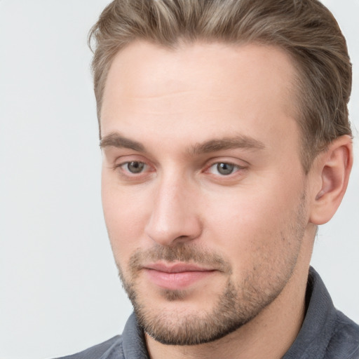 Joyful white young-adult male with short  brown hair and grey eyes