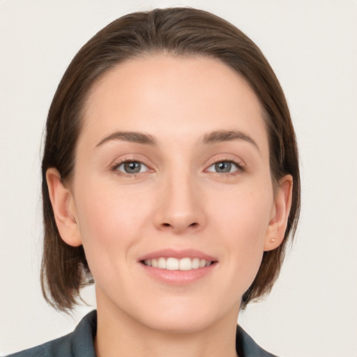 Joyful white young-adult female with medium  brown hair and grey eyes