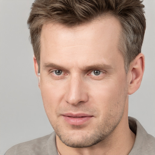 Joyful white adult male with short  brown hair and grey eyes