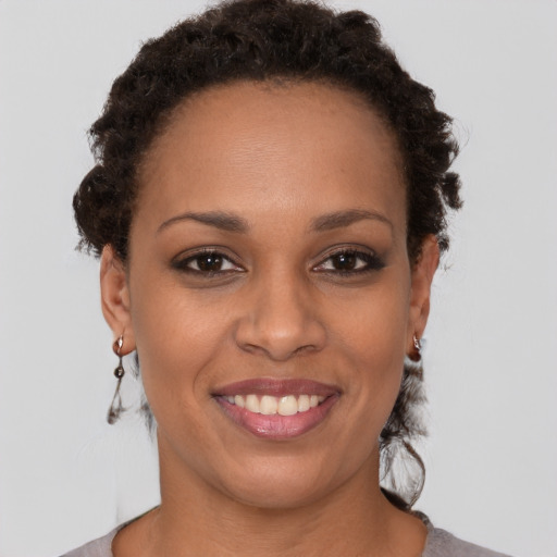 Joyful black young-adult female with short  brown hair and brown eyes