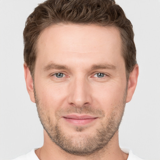 Joyful white young-adult male with short  brown hair and grey eyes