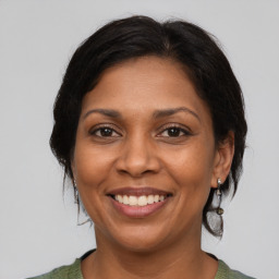 Joyful black adult female with medium  brown hair and brown eyes