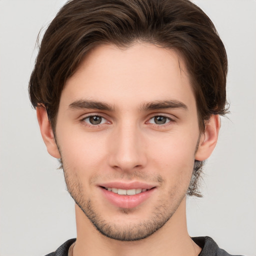 Joyful white young-adult male with short  brown hair and brown eyes