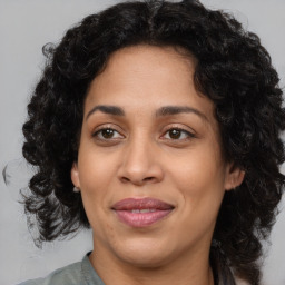 Joyful latino adult female with medium  brown hair and brown eyes