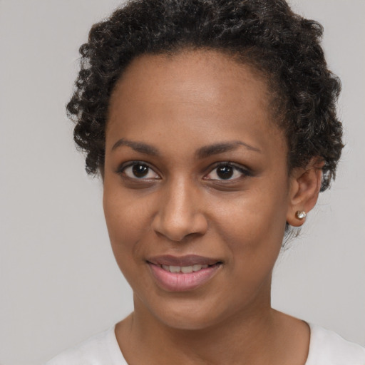 Joyful black young-adult female with short  brown hair and brown eyes
