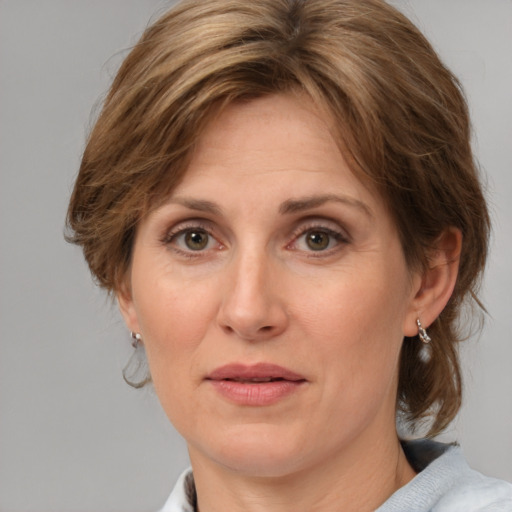 Joyful white adult female with medium  brown hair and grey eyes