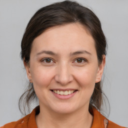 Joyful white young-adult female with medium  brown hair and brown eyes