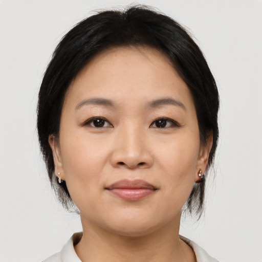 Joyful asian young-adult female with medium  brown hair and brown eyes