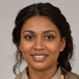 Joyful black young-adult female with medium  brown hair and brown eyes