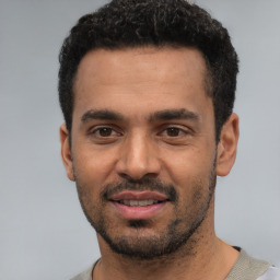 Joyful white young-adult male with short  black hair and brown eyes