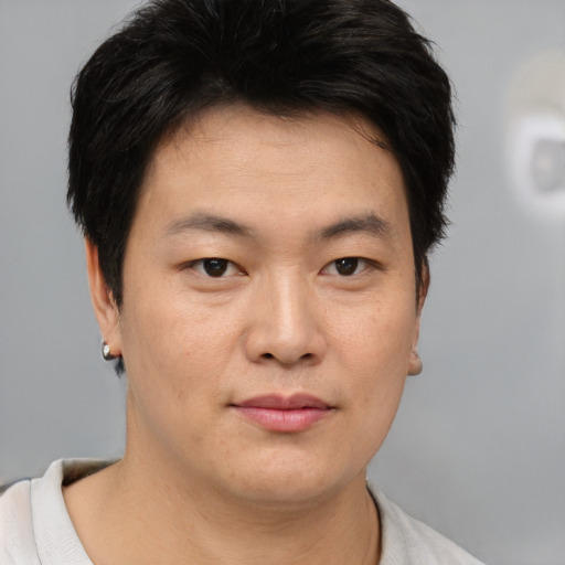 Joyful asian young-adult male with short  brown hair and brown eyes