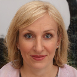 Joyful white adult female with medium  brown hair and blue eyes