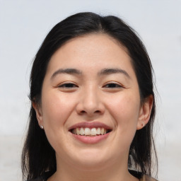 Joyful asian young-adult female with long  brown hair and brown eyes